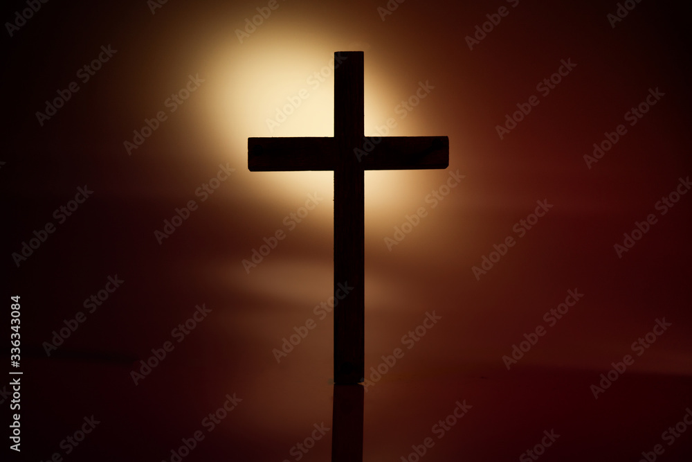Dramatic silhouette of the cross on brown background