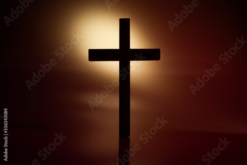 Dramatic silhouette of the cross on brown background © tarapatta