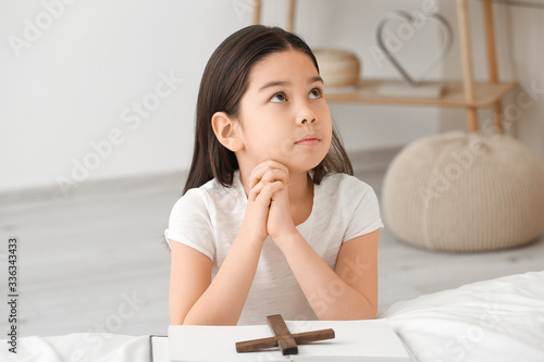 Cute little Asian girl pray...