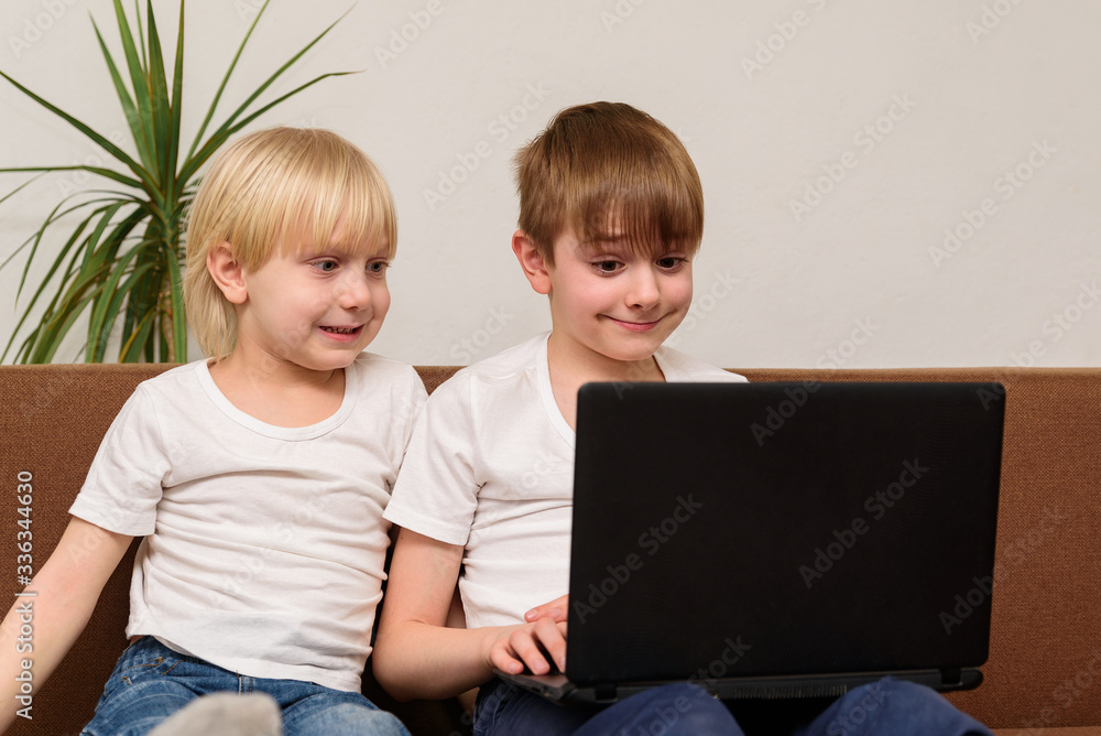 Two friends of teenager looking at laptop monitor. Programming for kids Two friends of teenager looking at laptop monitor. Programming for kids