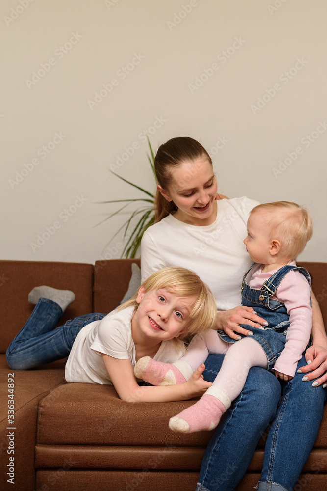Young mother and two children sitting on couch. Happy family concept. Vertical frame Young mother and two children sitting on couch. Happy family concept. Vertical frame