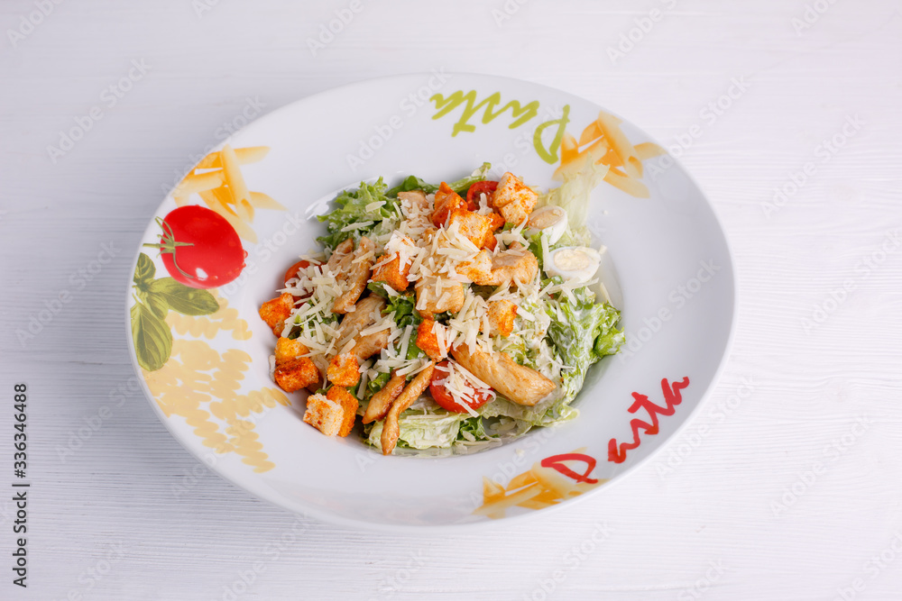 Caesar salad with chicken salad leaves on a light background, menu