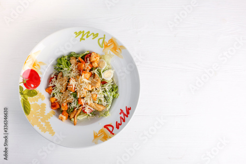 Caesar salad with chicken salad leaves on a light background, menu