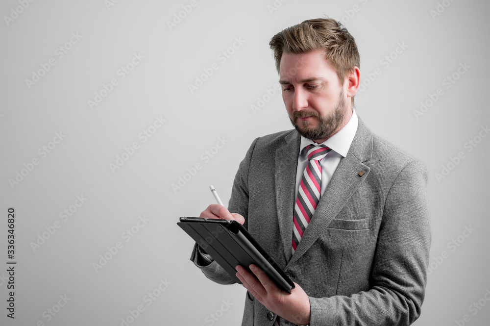 Portrait of business man wearing business clothes take notes on the tablet