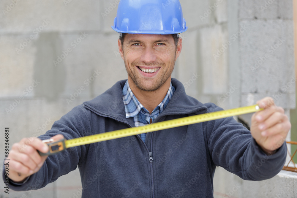 builder worker shows measures tape builder worker shows measures tape