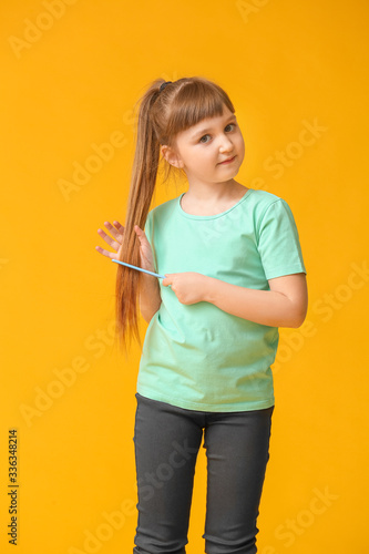 Little girl combing hair on...