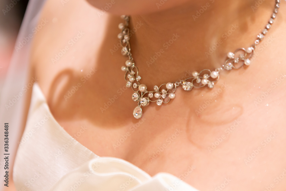 close up of a female hand with a pearl necklace