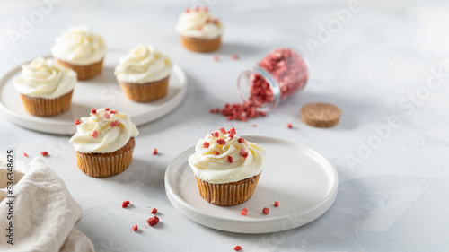 Sweet carrot cupcakes with whipped cream and dried fruits on white background. Bakery, confectionery banner, cookbook recipe, menu. Side view