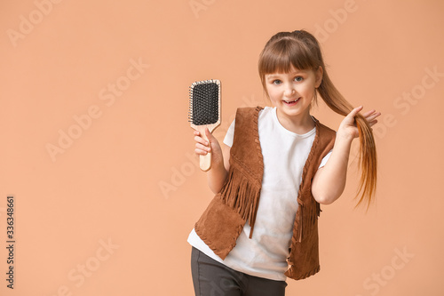 Little girl with hair brush...