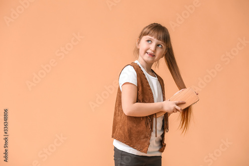 Little girl brushing hair o...
