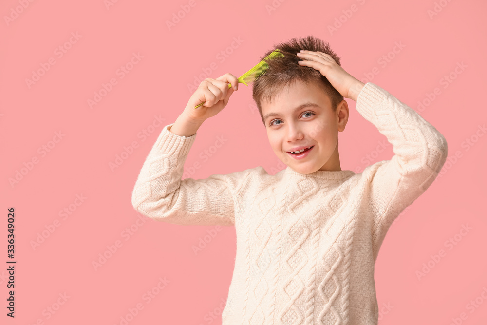 Little boy combing hair on color background Little boy combing hair on color background
