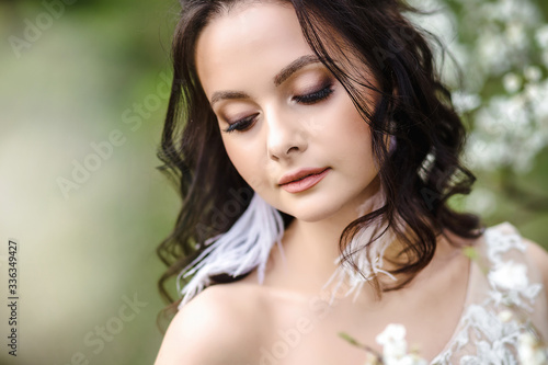 portrait of a bride in a wedding dress among blooming gardens  a beautiful young bride
