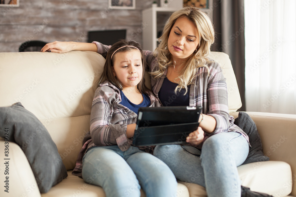 Sad little girl while watching a movie on tablet Sad little girl while watching a movie on tablet