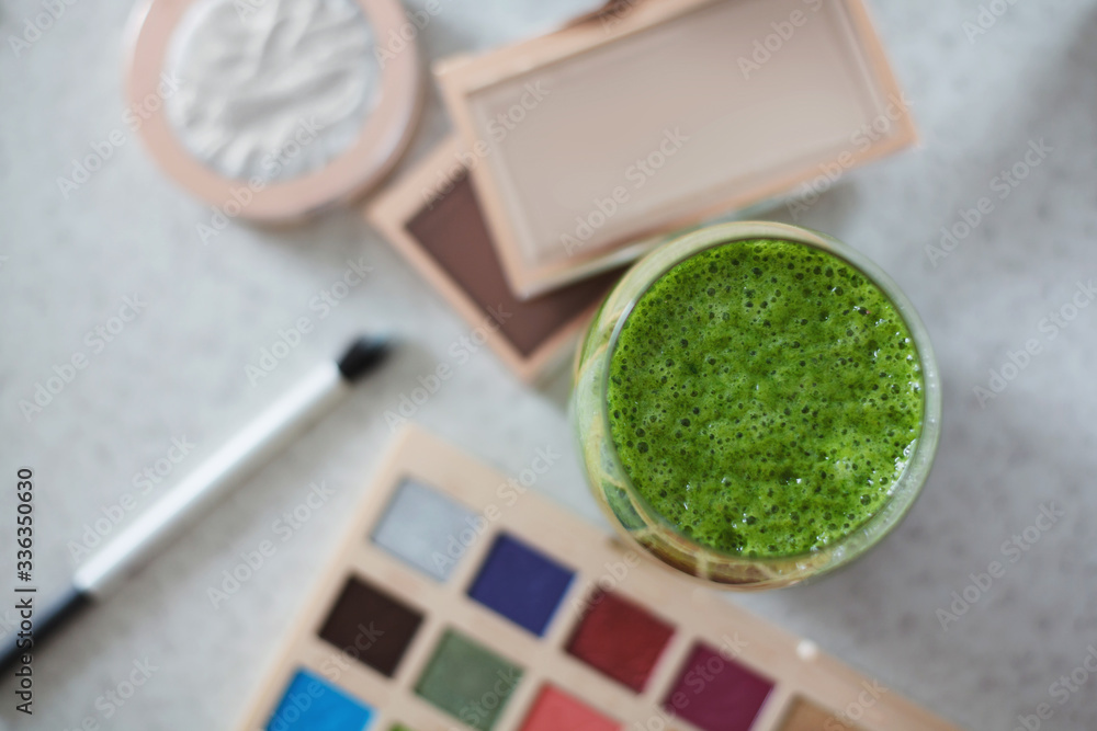 Top view of green smoothie on top of makeup table Top view of green smoothie on top of makeup table