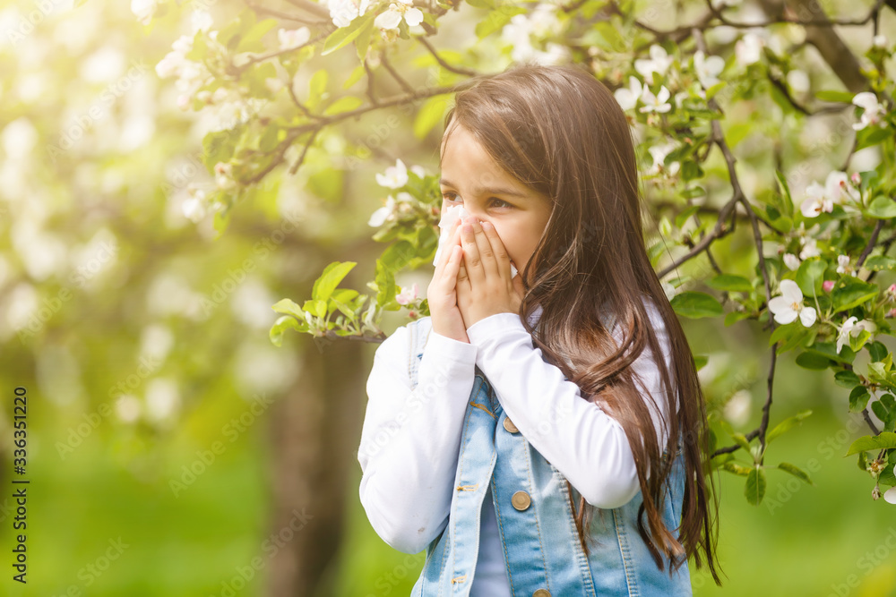 Little girl is blowing her nose while on green meadow Little girl is blowing her nose while on green meadow
