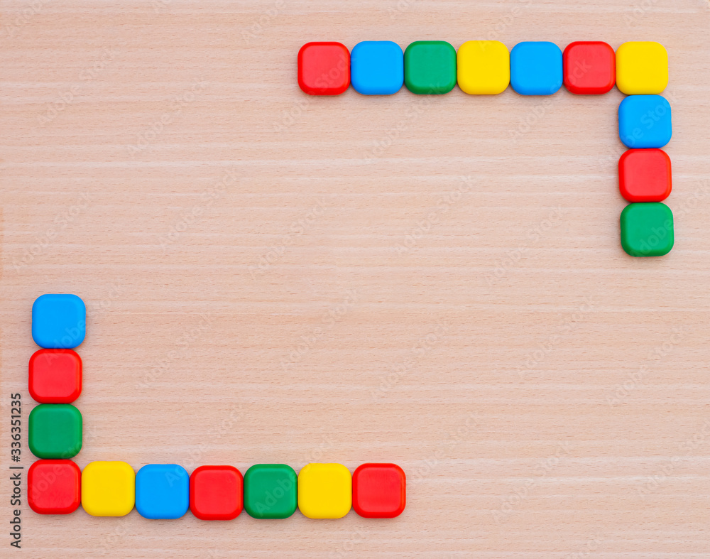 Various multi-colored geometric shapes on a wooden background. View from above. Background for text. Copy space Various multi-colored geometric shapes on a wooden background. View from above. Background for text. Copy space