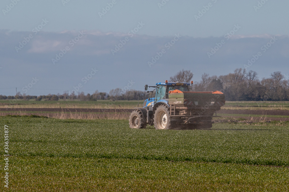 Obraz premium tractor fertilizer in a field , countryside