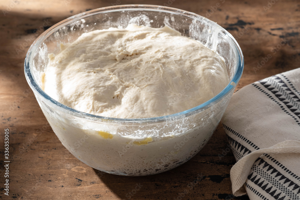 bowl of fresh raw dough on wooden background