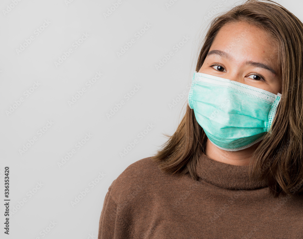 Asian young woman wearing a hygiene protective mask over her face on white background, protect from Coronavirus or Covid-19 epidemic.Covid-19 Concept, Asian young woman wearing a hygiene protective mask over her face on white background, protect from Coronavirus or Covid-19 epidemic.Covid-19 Concept,
