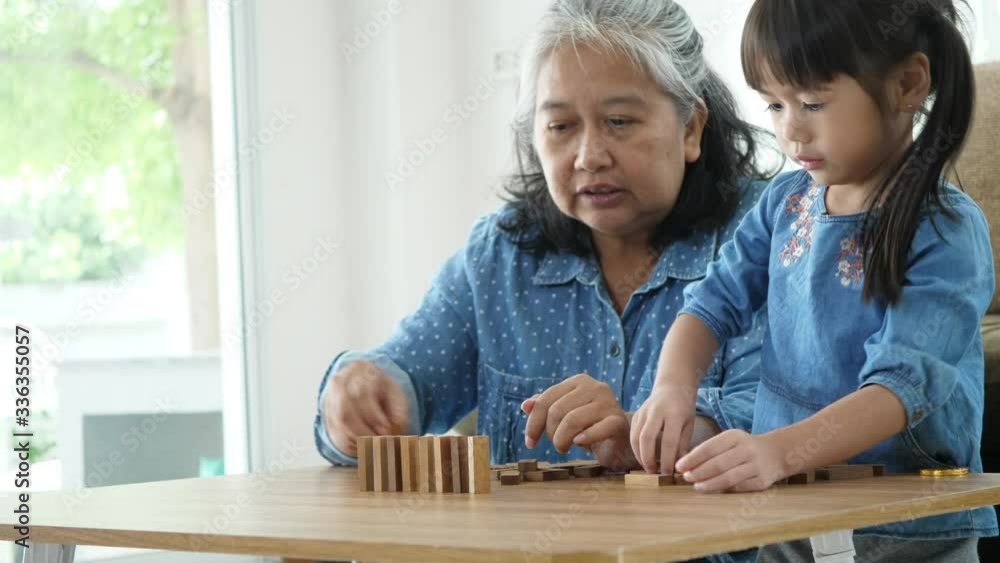 Grandmother and granddaughter stack play in a blocks game, Family relax time and holiday Grandmother and granddaughter stack play in a blocks game, Family relax time and holiday