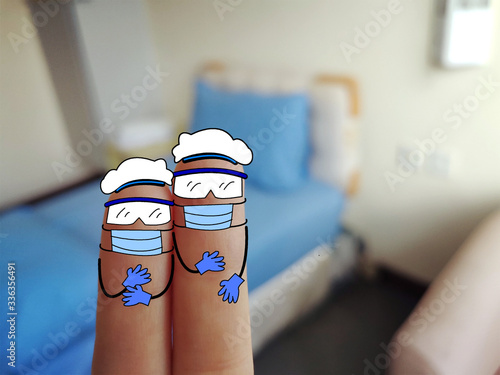 Two fingers are decorated as two person. They are wearing goggles, gloves, face masks and caps. They are working in hospital.