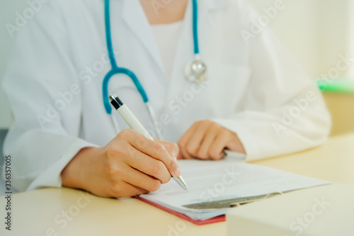  Concep Working efficiently : Hand of a female doctor sitting in a report writing a note taking medical planning in the office of the doctor in the hospital