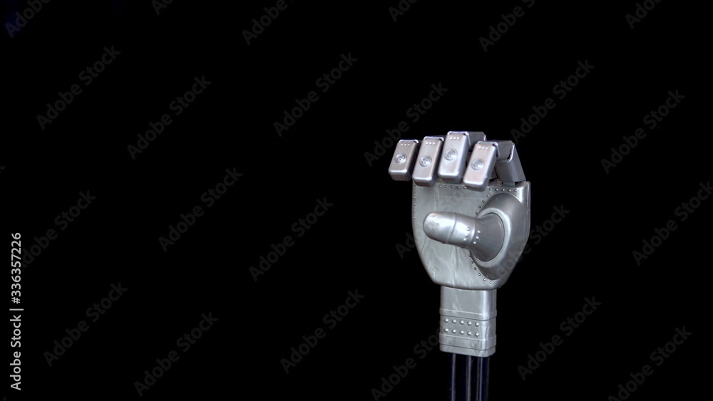Obraz premium A mechanical arm flexes fingers. Gray cyborg arm on a black background.