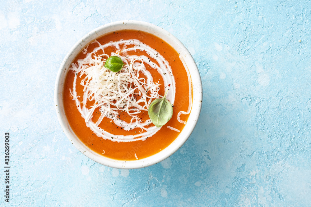 Pumpkin and carrot soup with cream on blue stone background. Pumpkin and carrot soup with cream on blue stone background.