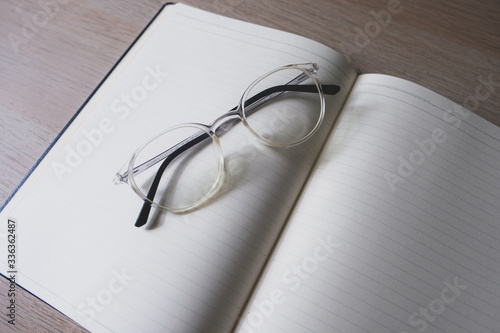 notebook and pen and glasses on the table