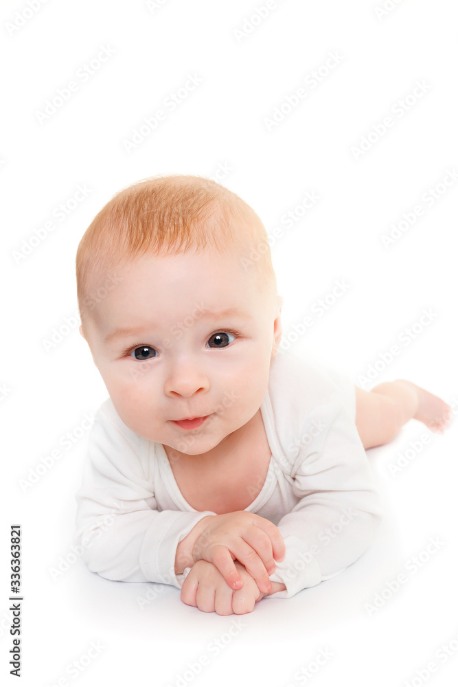 Adorable baby isolated on white.a small 4 month old baby is lying on a white surface and looking at the camera Adorable baby isolated on white.a small 4 month old baby is lying on a white surface and looking at the camera