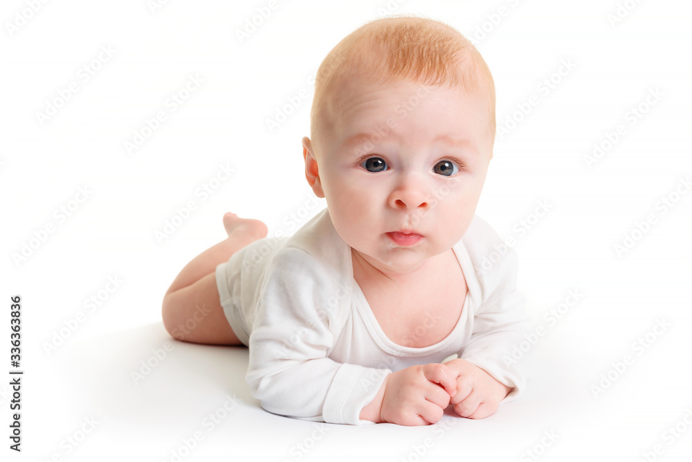Adorable baby isolated on white.a small 4 month old baby is lying on a white surface and looking at the camera
