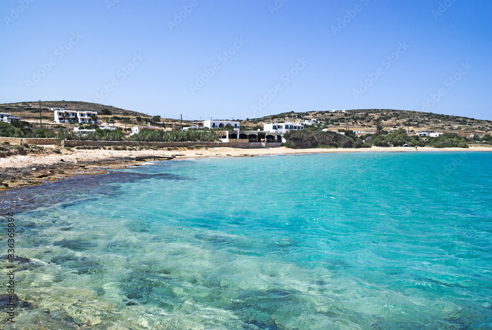 A secluded and tranquil beach on the Greek island of Koufonissi.  Crystal clear blue waters at Finikas beach..  A rocky foreshore gives way to a sandy beach backed by a small taverna.