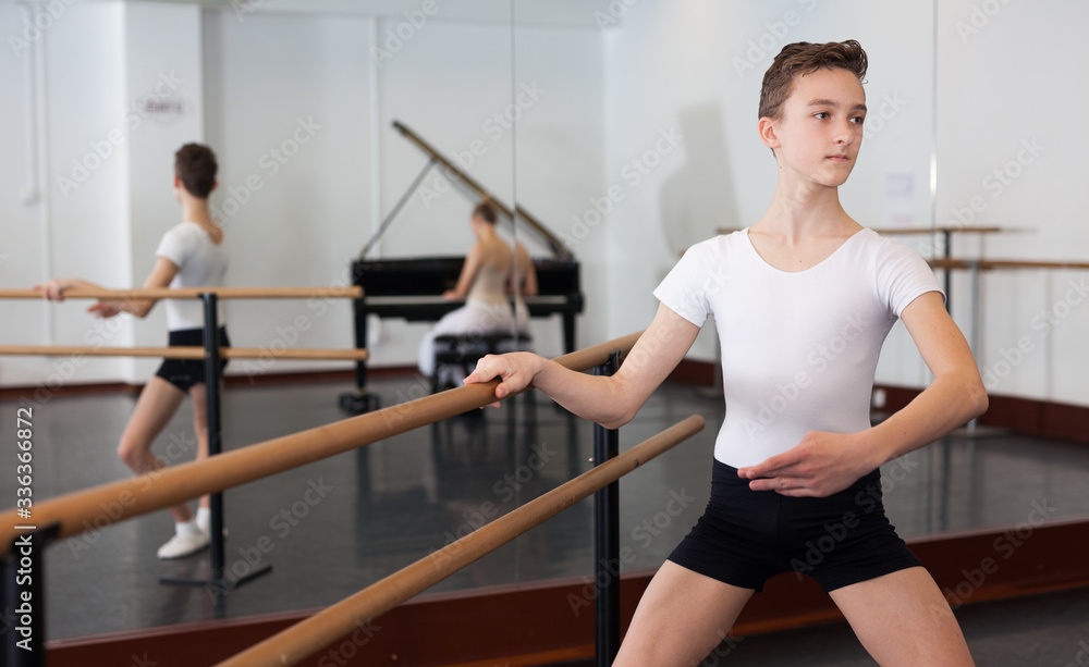Fototapeta premium Slim young man rehearsing ballet dance in studio