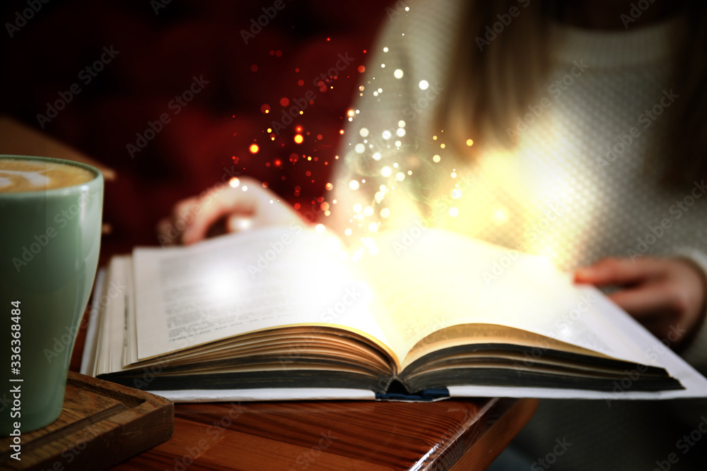 Naklejka premium Woman reading shiny magic book, closeup view
