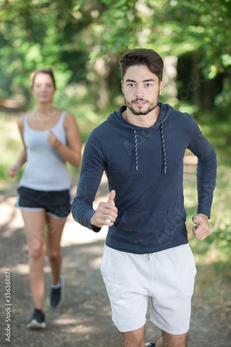 young sporty couple running in the forest © auremar