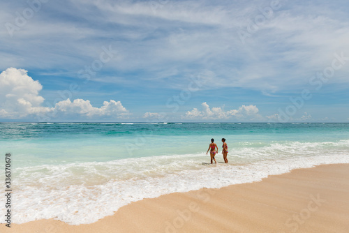Pandawa beach, Bali, Indonesia. - March, 2, 2017: Two young girls in a bathing suit are standing on the beach. Bali, Indonesia.