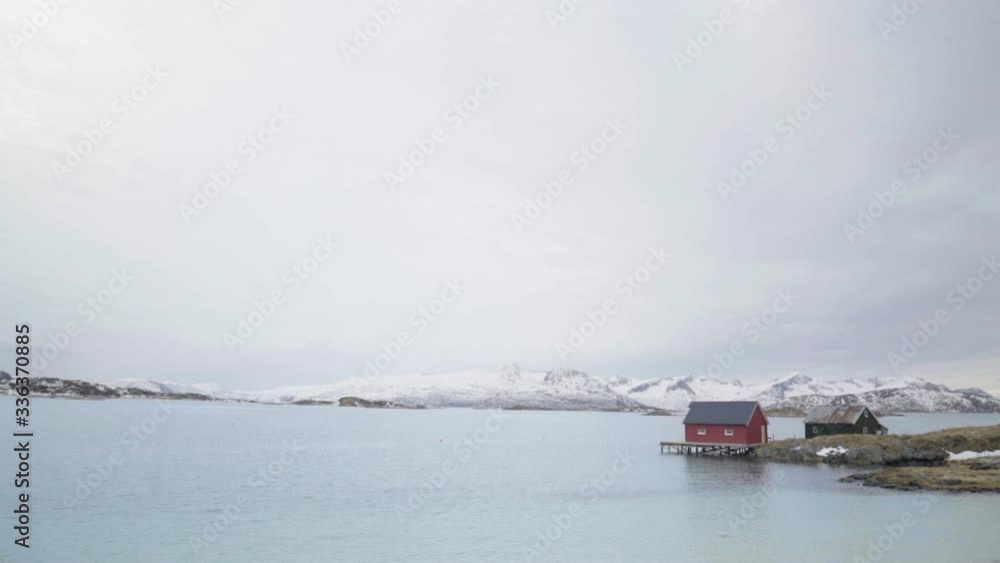 Classic red fisherman's house on a fjord in Norway with snow Classic red fisherman's house on a fjord in Norway with snow