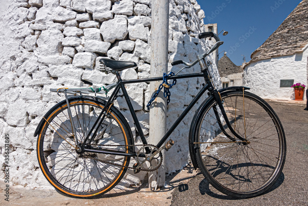Bicycle leaning against a wall, in Alberobello in Puglia.