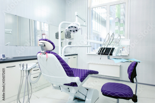 Interior of a modern dental clinic. The dentist s chair is ready to go. Special medical equipment in a white medical light