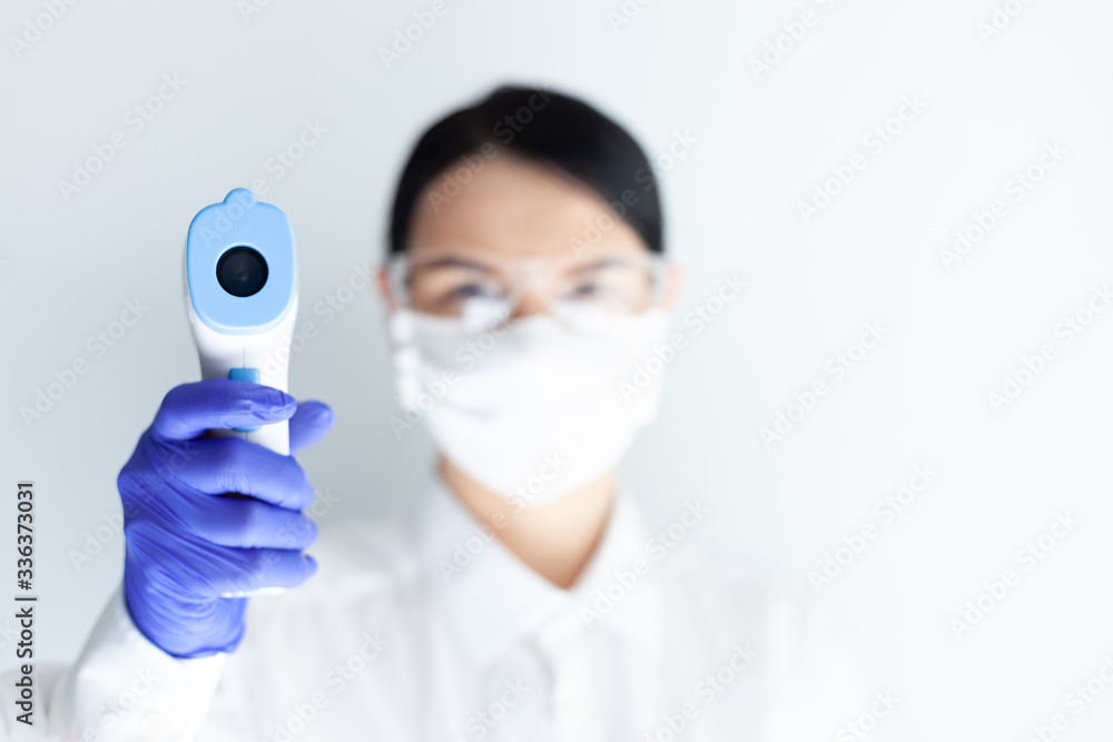 woman in medical mask measures body temperature woman in medical mask measures body temperature