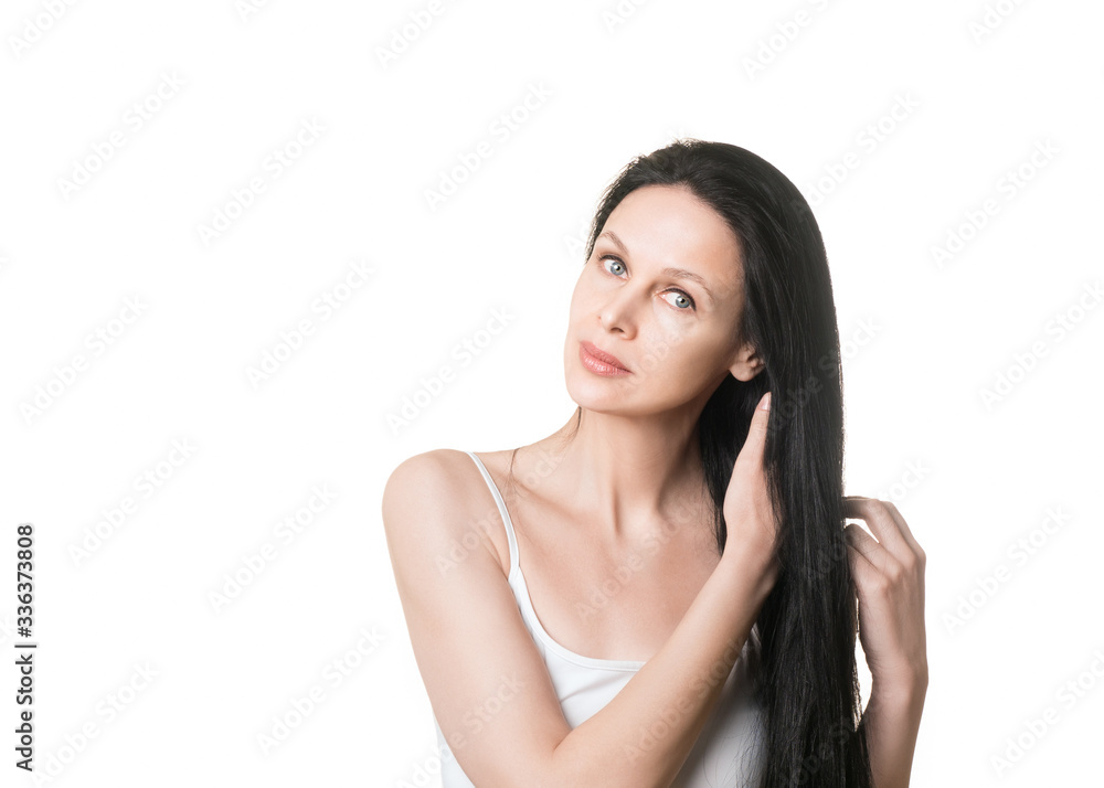 Natural beauty, caucasian beautiful female face with long loose black hair and bare shoulders, close up. Woman tilts her head to the side and fix her curls, isolated on white. Natural beauty, caucasian beautiful female face with long loose black hair and bare shoulders, close up. Woman tilts her head to the side and fix her curls, isolated on white.