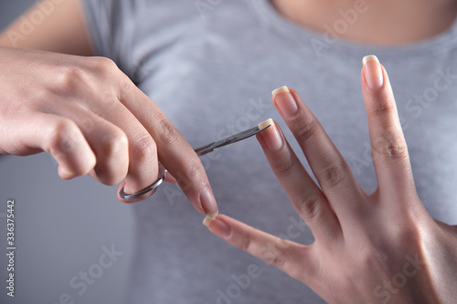woman cut the nail with scissors
