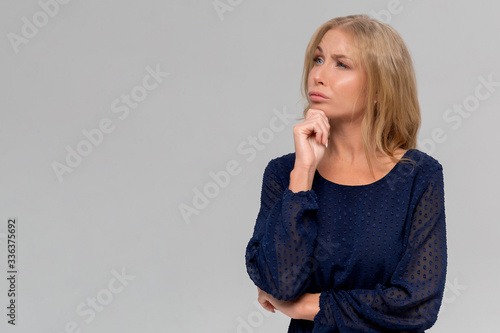 Thoughtful attractive young woman thinking and looking away over white background