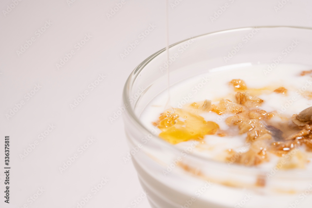 Macro shot - drop of mountain honey for granola and yogurt. The concept of a healthy diet, fitness Macro shot - drop of mountain honey for granola and yogurt. The concept of a healthy diet, fitness