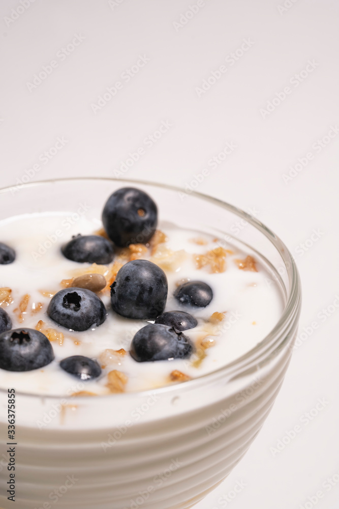 Fresh blueberries in healthy breakfast into a glass with yogurt. Concept of proper nutrition and healthy lifestyle Fresh blueberries in healthy breakfast into a glass with yogurt. Concept of proper nutrition and healthy lifestyle