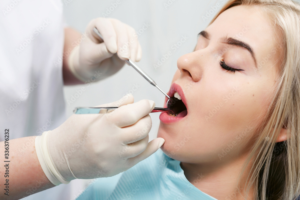Dentist examining a patient's teeth in modern dentistry office. Closeup cropped picture with copyspace Dentist examining a patient's teeth in modern dentistry office. Closeup cropped picture with copyspace
