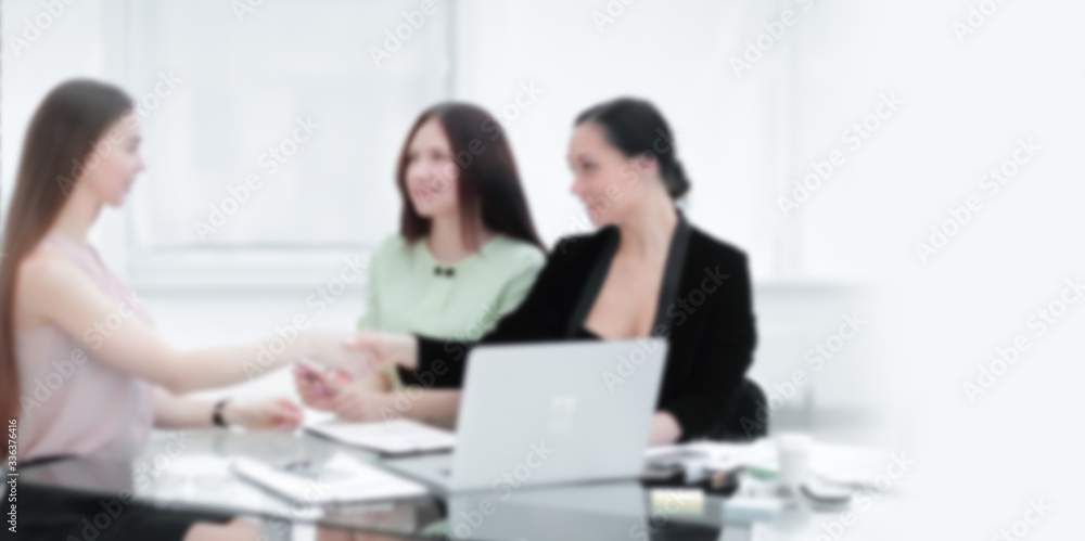 handshake of business partners at your Desk.woman and business. Background for text with people in blur