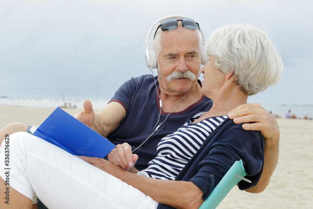 senior couple dancing at the beach on a grey day