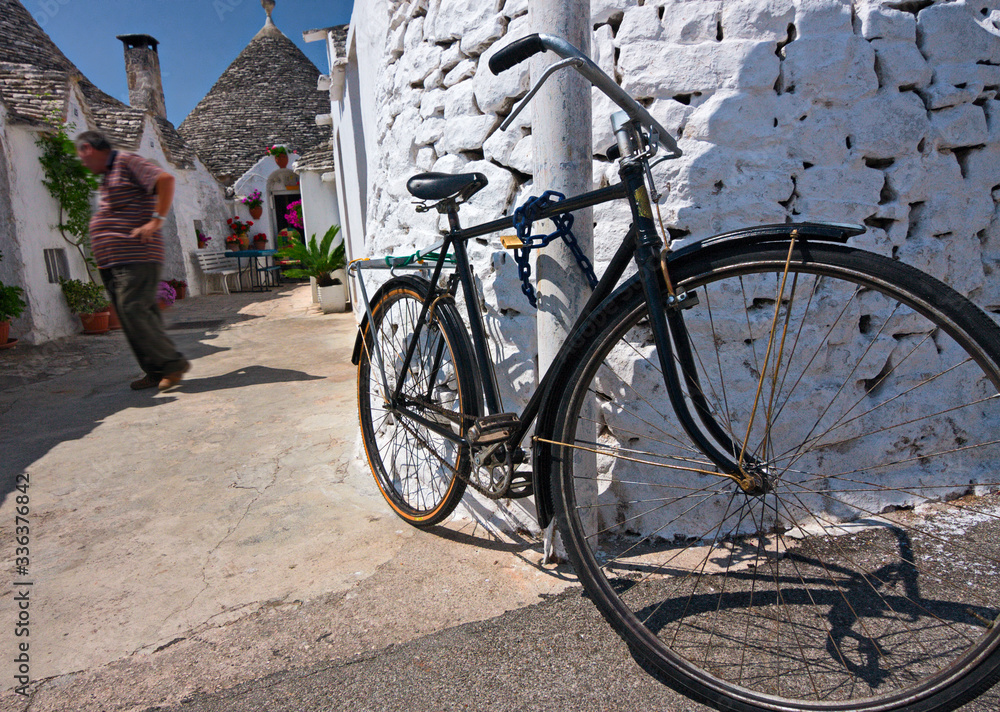 Bicycle chained to a wall, in Alberobello in Puglia.