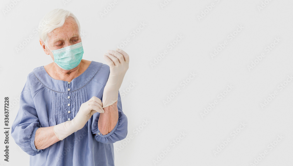 Front view of elderly woman with medical mask and surgical gloves Front view of elderly woman with medical mask and surgical gloves